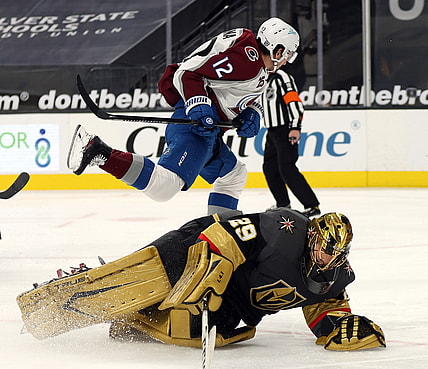 Feb 16, 2021; Las Vegas, Nevada, USA; Colorado Avalanche center Jayson Megna (12) skates over Vegas Golden Knights goalie Marc-Andre Fleury (29) during the third period at T-Mobile Arena. Mandatory Credit:  Isaac Brekken/Pool Photos-USA TODAY Sports