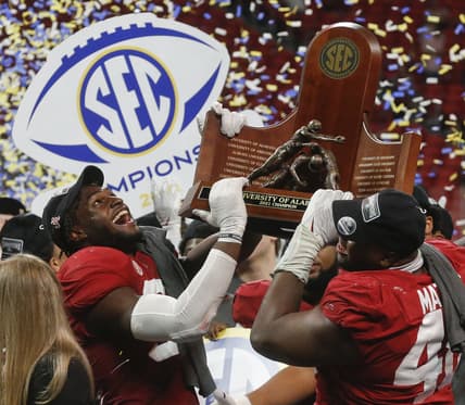 Dec 4, 2021; Atlanta, GA, USA; Alabama Crimson Tide linebacker Will Anderson Jr. (31) and defensive lineman Phidarian Mathis (48) hoist the trophy after defeating the Georgia Bulldogs in the SEC championship game at Mercedes-Benz Stadium. Alabama won 41-24. Mandatory Credit: Gary Cosby Jr.-USA TODAY Sports