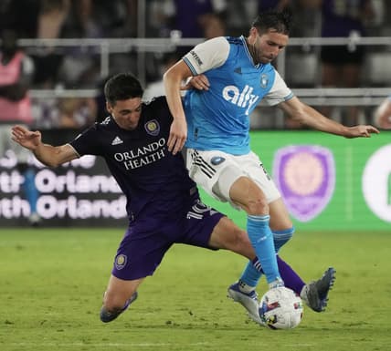 Apr 30, 2022; Orlando, Florida, USA; Orlando City midfielder Mauricio Pereyra (10) tackles Charlotte FC midfielder Brandt Bronico (13) during the second half at Exploria Stadium. Mandatory Credit: Kirby Lee-USA TODAY Sports