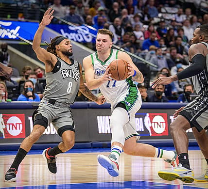 Dec 7, 2021; Dallas, Texas, USA; Dallas Mavericks guard Luka Doncic (77) drives to the basket past Brooklyn Nets guard Patty Mills (8) during the second quarter at the American Airlines Center. Mandatory Credit: Jerome Miron-USA TODAY Sports