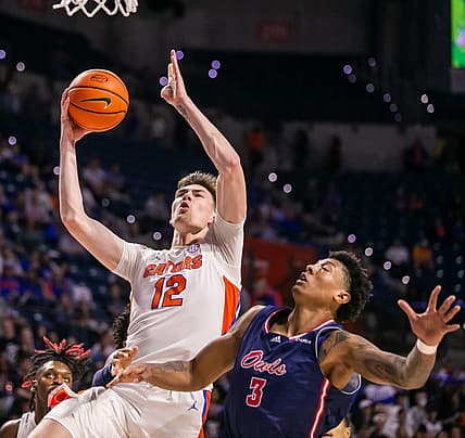 Florida Gators forward Colin Castleton (12) drives to the basket over Florida Atlantic Owls forward Giancarlo Rosado (3).  The Florida Gators men  s basketball team hosted the Florida Atlantic Owls at Billy Donovan Court at Exactech Arena in Gainesville, FL on Monday, November 14, 2022. The score was tied 35-35 at the half.  [Doug Engle/Gainesville Sun]

Gai Ufbasketballfau