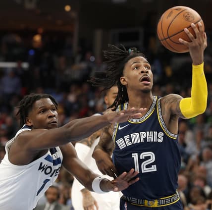 Apr 19, 2022; Memphis, Tennessee, USA; Memphis Grizzlies guard Ja Morant (12) is guarded by Minnesota Timberwolves forward Anthony Edwards (1) as he goes to shoot the ball during the second half of game two of the first round for the 2022 NBA playoffs at FedExForum. Mandatory Credit: Christine Tannous-USA TODAY Sports