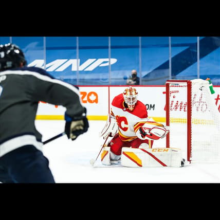 Feb 4, 2021; Winnipeg, Manitoba, CAN; Calgary Flames goalie Jacob Markstrom (25) makes a save on a shot by Winnipeg Jets forward Andrew Copp (9) during the second period at Bell MTS Place. Mandatory Credit: Terrence Lee-USA TODAY Sports