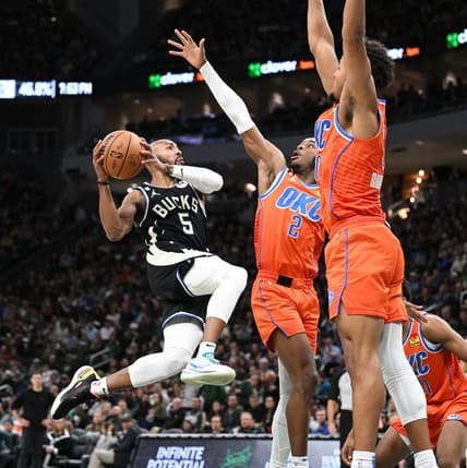 Nov 5, 2022; Milwaukee, Wisconsin, USA; Milwaukee Bucks guard Jevon Carter (5) drives to the basket against Oklahoma City Thunder guard Shai Gilgeous-Alexander (2) in the second quarter at Fiserv Forum. Mandatory Credit: Michael McLoone-USA TODAY Sports