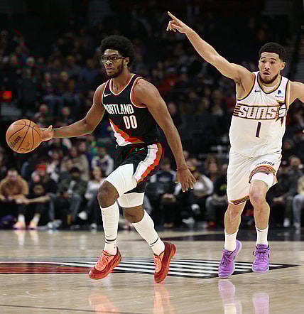 Jan 14, 2024; Portland, Oregon, USA; Portland Trail Blazers guard Scoot Henderson (00) dribbles the ball as Phoenix Suns guard Devin Booker (1) directs traffic in the first quarter at Moda Center. Mandatory Credit: Jaime Valdez-USA TODAY Sports