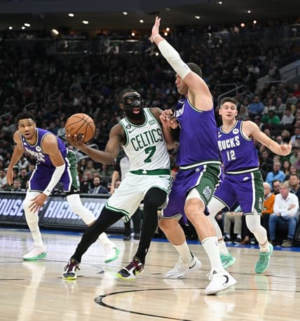 Mar 30, 2023; Milwaukee, Wisconsin, USA; Boston Celtics guard Jaylen Brown (7) drives to the basket against Milwaukee Bucks center Brook Lopez (11) at Fiserv Forum. Mandatory Credit: Michael McLoone-USA TODAY Sports