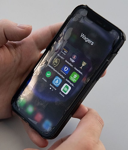 Sports betting apps are shown on a smart phone.