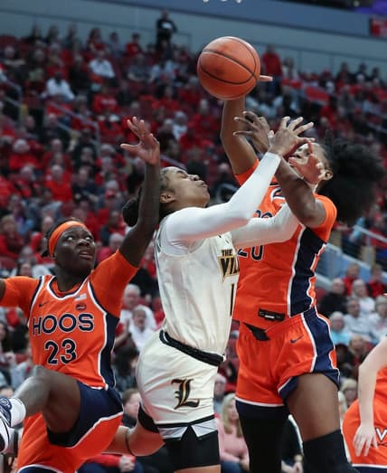 U of L's Merissah Russell (13) gets tied up with Virgina defenders during their game at the KFC Yum! Center in Louisville, Ky. on Feb. 25, 2024.