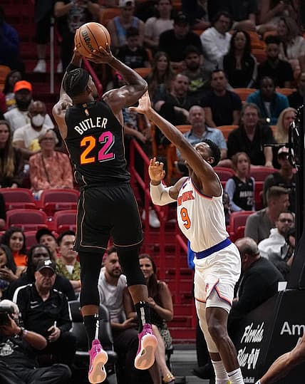 Mar 25, 2022; Miami, Florida, USA; Miami Heat forward Jimmy Butler (22) shoots the ball over New York Knicks guard RJ Barrett (9) during the second half at FTX Arena. Mandatory Credit: Jasen Vinlove-USA TODAY Sports