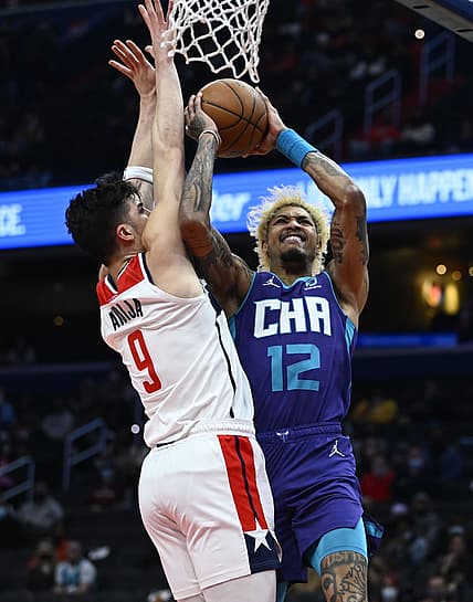 Jan 3, 2022; Washington, District of Columbia, USA; Charlotte Hornets guard Kelly Oubre Jr. (12) shoots over Washington Wizards forward Deni Avdija (9) during the first half at Capital One Arena. Mandatory Credit: Brad Mills-USA TODAY Sports