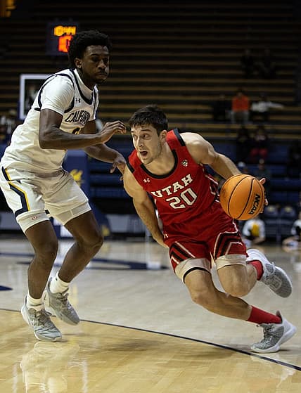 Dec 29, 2022; Berkeley, California, USA; Utah Utes guard Lazar Stefanovic (20) drives around California Golden Bears guard Marsalis Roberson (0) during the first half at Haas Pavilion. Mandatory Credit: D. Ross Cameron-USA TODAY Sports
