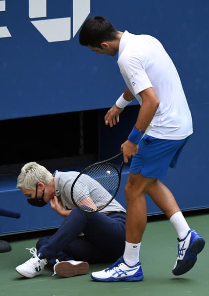 Sep 6, 2020; Flushing Meadows, New York, USA; Novak Djokovic of Serbia checks on a line judge after he unintentionally hit her with a tennis ball after losing a game to Pablo Carreno Busta of Spain (not pictured) on day seven of the 2020 U.S. Open tennis tournament at USTA Billie Jean King National Tennis Center. Mandatory Credit: Danielle Parhizkaran-USA TODAY Sports