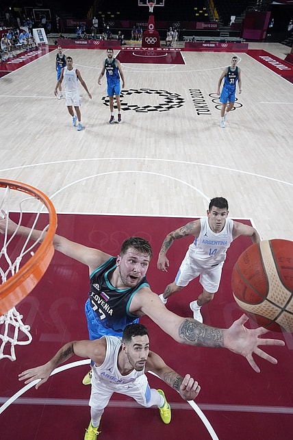 Jul 26, 2021; Saitama, Japan; Slovenia player Luka Doncic (77) and Argentina player Luca Vildoza (17) battle for a rebound during the Tokyo 2020 Olympic Summer Games at Saitama Super Arena. Mandatory Credit: Kyle Terada-USA TODAY Sports