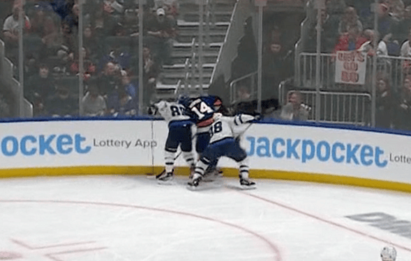 New York Islanders Bo Horvat pinning puck along boards.
