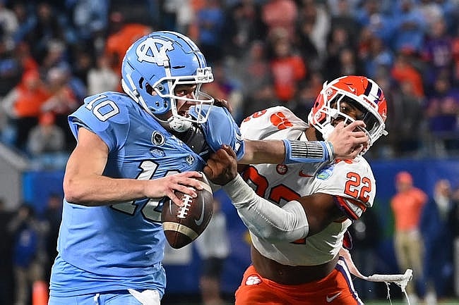 Dec 3, 2022; Charlotte, North Carolina, USA;  North Carolina Tar Heels quarterback Drake Maye (10) with the ball as Clemson Tigers linebacker Trenton Simpson (22) defends in the second quarter at Bank of America Stadium. Mandatory Credit: Bob Donnan-USA TODAY Sports