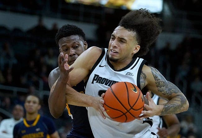Providence Friars guard Devin Carter drives to the PC hoop against Merrimack defender Devon Savage after scooping up a loose ball in the first half.