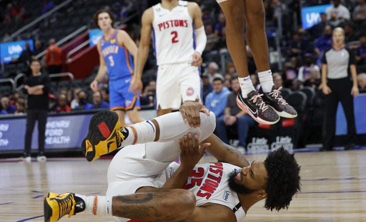 Oct 11, 2022; Detroit, Michigan, USA; Detroit Pistons forward Marvin Bagley III (35) grabs his knee and Oklahoma City Thunder forward Jeremiah Robinson-Earl (50) dunks in the first half at Little Caesars Arena. Mandatory Credit: Rick Osentoski-USA TODAY Sports