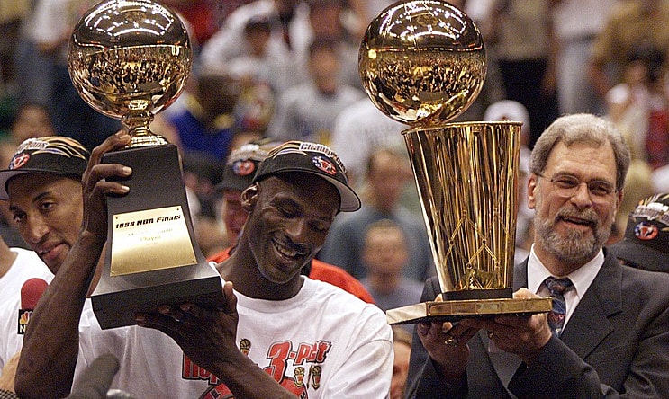 Michael Jordan holds the MVP trophy and coach Phil Jackson holds the championship trophy after the Bulls beat the Jazz to win their sixth title in 1998