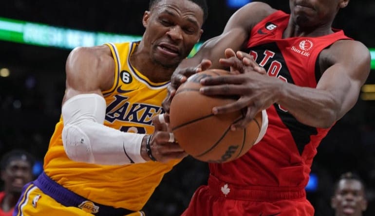 Dec 7, 2022; Toronto, Ontario, CAN; Los Angeles Lakers guard Russell Westbrook (0) battles for the ball with Toronto Raptors forward Christian Koloko (35) during the second quarter at the Scotiabank Arena.  Mandatory Credit: Nick Turchiaro-USA TODAY Sports