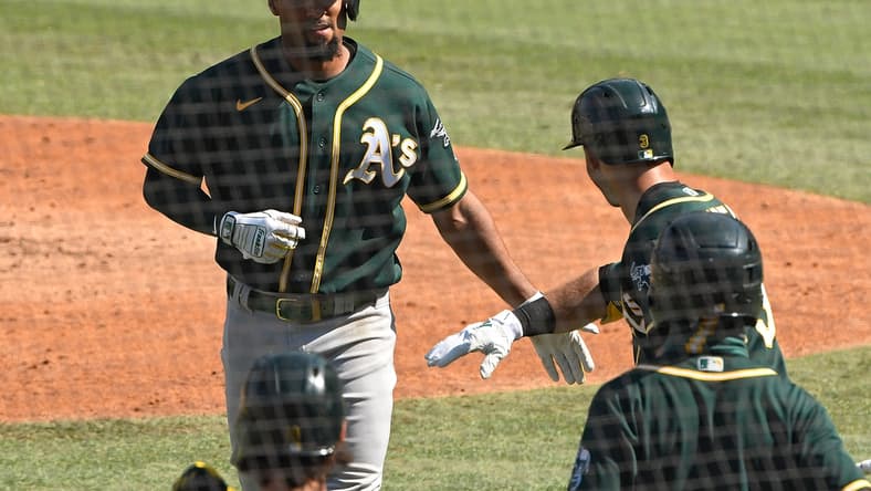 Oct 7, 2020; Los Angeles, California, USA; Oakland Athletics shortstop Marcus Semien (10) is congratulated by second baseman Tommy La Stella (3) after hitting a solo home run off of Houston Astros starting pitcher Jose Urquidy (not pictured) during the fifth inning in game three of the 2020 ALDS at Dodger Stadium. Mandatory Credit: Robert Hanashiro-USA TODAY Sports