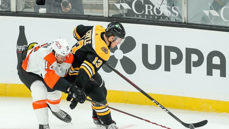 Jan 23, 2021; Boston, Massachusetts, USA; Philadelphia Flyers left wing Michael Raffl (12) defends Boston Bruins center Charlie Coyle (13) during the first period at TD Garden. Mandatory Credit: Paul Rutherford-USA TODAY Sports