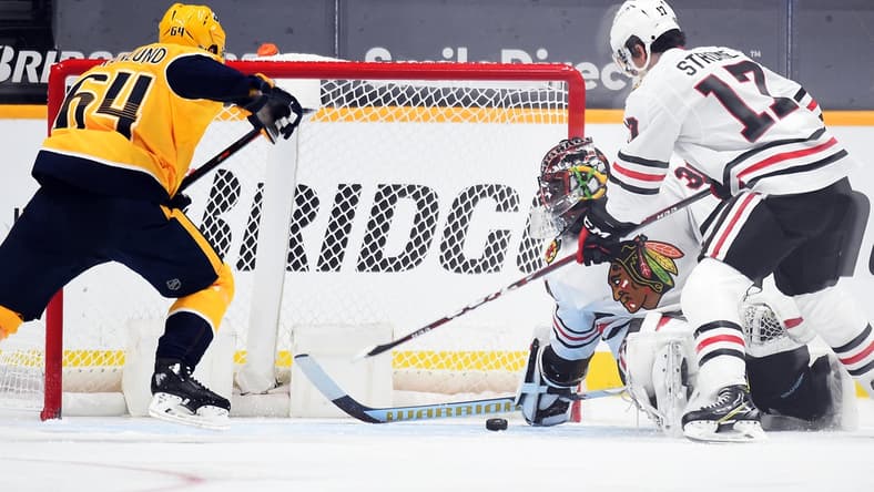 Jan 26, 2021; Nashville, Tennessee, USA; Chicago Blackhawks goaltender Malcolm Subban (30) covers a puck in the crease against Nashville Predators center Mikael Granlund (64) during the second period at Bridgestone Arena. Mandatory Credit: Christopher Hanewinckel-USA TODAY Sports