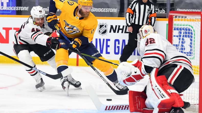 Jan 27, 2021; Nashville, Tennessee, USA; Nashville Predators defenseman Mattias Ekholm (14) skates the puck toward the net past Chicago Blackhawks defenseman Lucas Carlsson (46) during the first period at Bridgestone Arena. Mandatory Credit: Christopher Hanewinckel-USA TODAY Sports