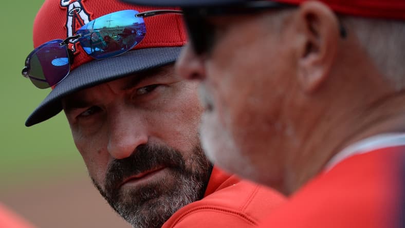 Mar 10, 2020; Peoria, Arizona, USA; Los Angeles Angels pitching coach Mickey Callaway (left) talks with manager Joe Maddon during the second inning of a spring training game against the Seattle Mariners at Peoria Stadium. Mandatory Credit: Joe Camporeale-USA TODAY Sports