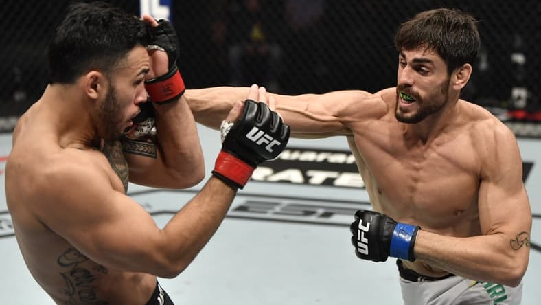 Jan 23, 2021; Abu Dhabi, United Arab Emirates; Antonio Carlos Junior of Brazil punches Brad Tavares in a middleweight fight during the UFC 257 event inside Etihad Arena on UFC Fight Island.  Mandatory Credit: Jeff Bottari/Handout Photo via USA TODAY Sports