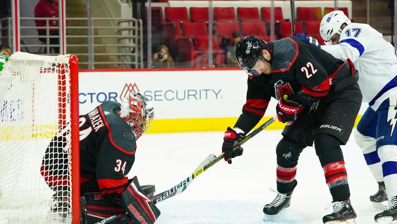 Jan 28, 2021; Raleigh, North Carolina, USA; Carolina Hurricanes goaltender Petr Mrazek (34) and defenseman Brett Pesce (22) watch the puck against the Tampa Bay Lightning at PNC Arena. Mandatory Credit: James Guillory-USA TODAY Sports