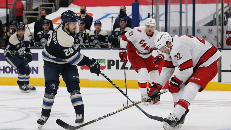 Feb 7, 2021; Columbus, Ohio, USA; Carolina Hurricanes defenseman Brett Pesce (22) knocks down the pass attempt of Columbus Blue Jackets right wing Oliver Bjorkstrand (28) during the first period at Nationwide Arena. Mandatory Credit: Russell LaBounty-USA TODAY Sports