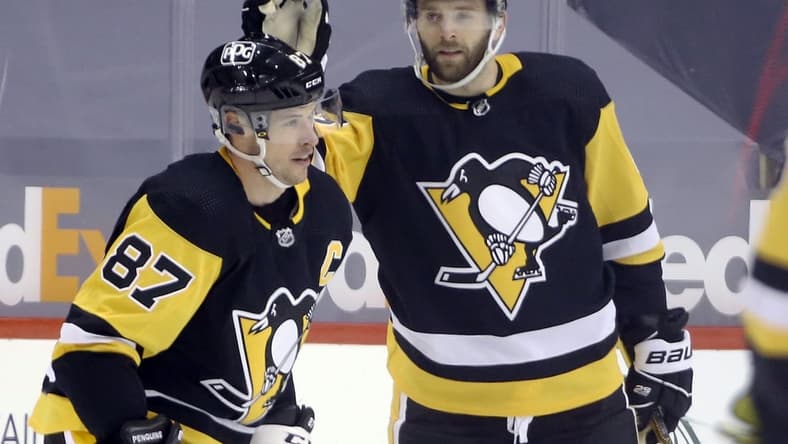 Feb 14, 2021; Pittsburgh, Pennsylvania, USA; Pittsburgh Penguins right wing Bryan Rust (17) congratulates center Sidney Crosby (87) on his goal against the Washington Capitals during the third period at PPG Paints Arena. The Penguins won 6-3. Mandatory Credit: Charles LeClaire-USA TODAY Sports