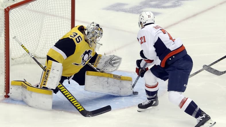 Feb 16, 2021; Pittsburgh, Pennsylvania, USA; Pittsburgh Penguins goaltender Tristan Jarry (35) makes a save against Washington Capitals right wing Garnet Hathaway (21) during the first period at PPG Paints Arena. Mandatory Credit: Charles LeClaire-USA TODAY Sports