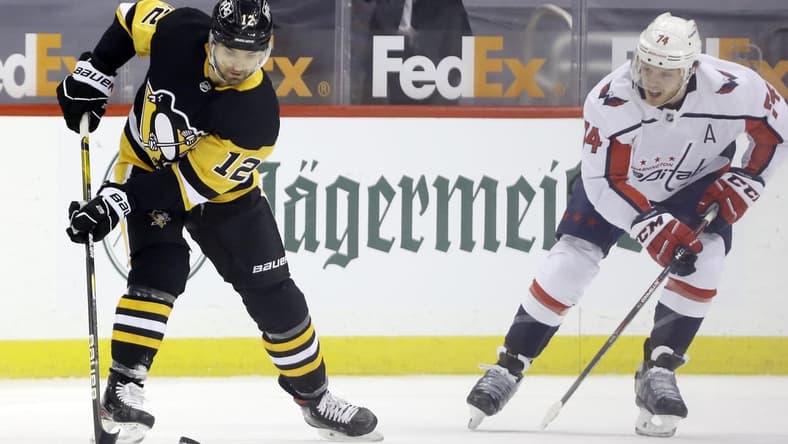 Feb 14, 2021; Pittsburgh, Pennsylvania, USA; Pittsburgh Penguins center Zach Aston-Reese (12) handles the puck against Washington Capitals defenseman John Carlson (74) during the first period at PPG Paints Arena. Pittsburgh won 6-3. Mandatory Credit: Charles LeClaire-USA TODAY Sports