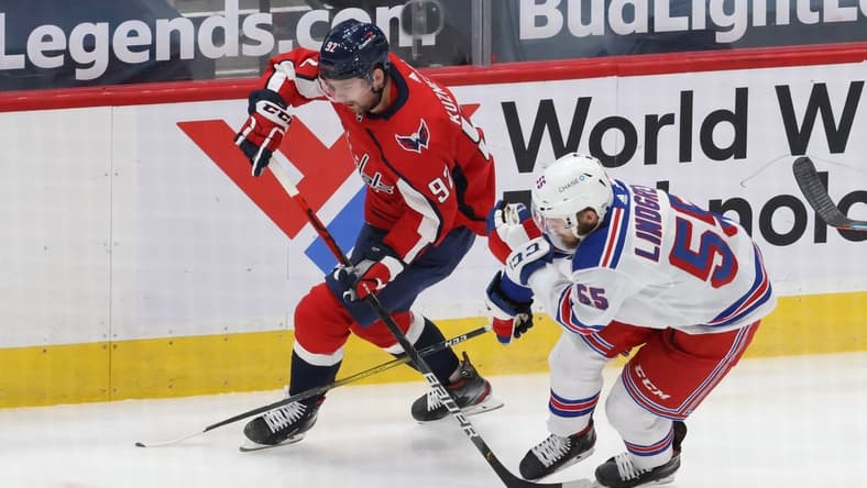 Feb 20, 2021; Washington, District of Columbia, USA; Washington Capitals center Evgeny Kuznetsov (92). Skates with the puck as New York Rangers defenseman Ryan Lindgren (55) defends in the first period at Capital One Arena. Mandatory Credit: Geoff Burke-USA TODAY Sports