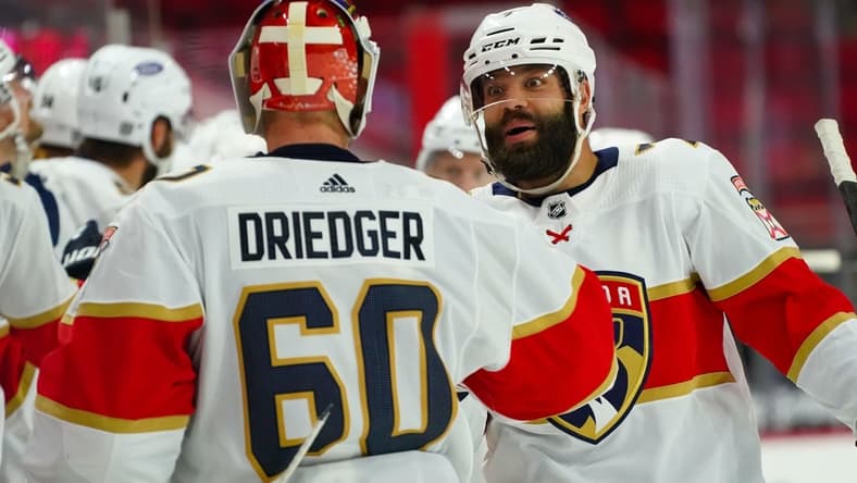 Feb 17, 2021; Raleigh, North Carolina, USA; Florida Panthers defenseman Radko Gudas (7) celebrates a goal with goaltender Chris Driedger (60) against the Carolina Hurricanes at PNC Arena. Mandatory Credit: James Guillory-USA TODAY Sports