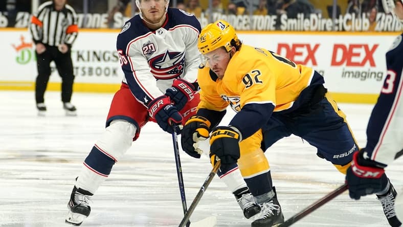 Feb 27, 2021; Nashville, Tennessee, USA; Nashville Predators center Ryan Johansen (92) and Columbus Blue Jackets center Jack Roslovic (96) fight for the puck during the third period at Bridgestone Arena. Mandatory Credit: Steve Roberts-USA TODAY Sports