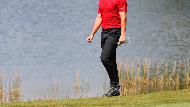 Feb 28, 2021; Bradenton, Florida, USA; Rory McIlroy walks to the second green wearing red and black honoring Tiger Woods during the final round of World Golf Championships at The Concession golf tournament at The Concession Golf Club. Mandatory Credit: Mike Watters-USA TODAY Sports