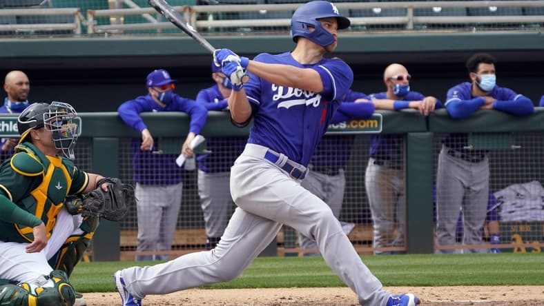 Feb 28, 2021; Mesa, Arizona, USA; Los Angeles Dodgers shortstop Corey Seager (5) hits a RBI single against the Oakland Athletics in the third inning at Hohokam Stadium. Mandatory Credit: Rick Scuteri-USA TODAY Sports