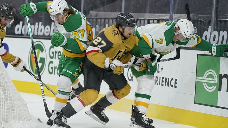 Mar 3, 2021; Las Vegas, Nevada, USA; Minnesota Wild center Nico Sturm (7), Vegas Golden Knights defenseman Shea Theodore (27) and left wing Kirill Kaprizov (97) battle for the puck during the first period of an NHL hockey game Wednesday, March 3, 2021, in Las Vegas. Mandatory Credit: John Locher-POOL PHOTOS-USA TODAY Sports