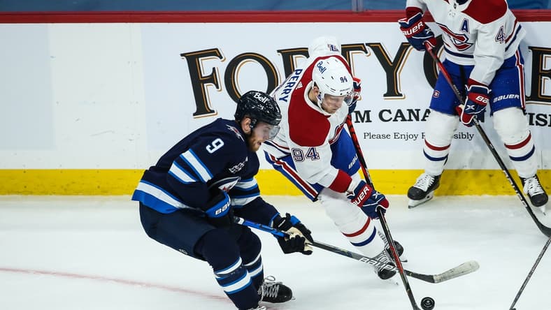 Mar 15, 2021; Winnipeg, Manitoba, CAN; Montreal Canadiens forward Corey Perry (94) battles Winnipeg Jets forward Andrew Copp (9) for the puck during the first period at MTS Place. Mandatory Credit: Terrence Lee-USA TODAY Sports