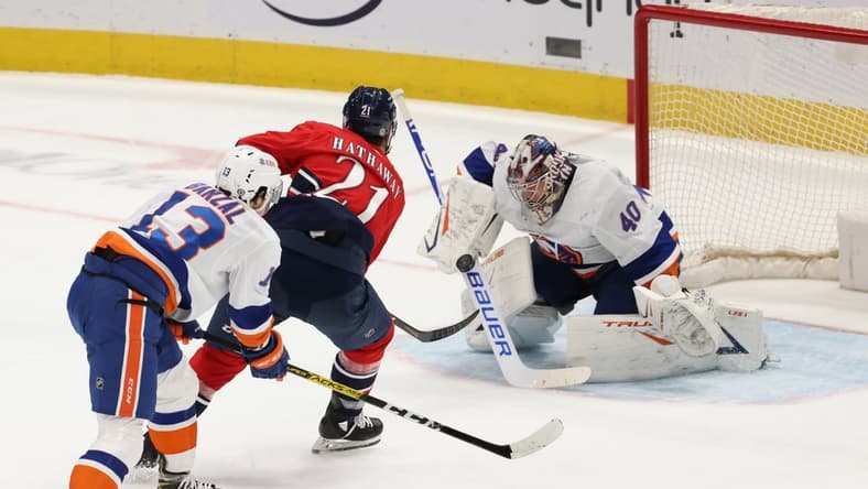 Mar 16, 2021; Washington, District of Columbia, USA;  New York Islanders goaltender Semyon Varlamov (40) makes a save on Washington Capitals right wing Garnet Hathaway (21) as Islanders center Mathew Barzal (13) defends in the second period at Capital One Arena. Mandatory Credit: Geoff Burke-USA TODAY Sports