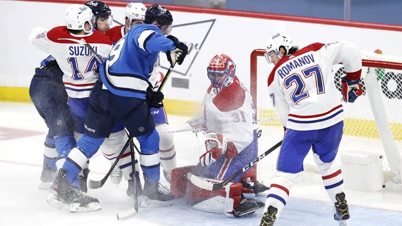 Mar 17, 2021; Winnipeg, Manitoba, CAN; Montreal Canadiens goaltender Carey Price (31) watches the puck as Winnipeg Jets center Andrew Copp (9) and defenseman Alexander Romanov (27) try for a rebound in the second period at Bell MTS Place. Mandatory Credit: James Carey Lauder-USA TODAY Sports