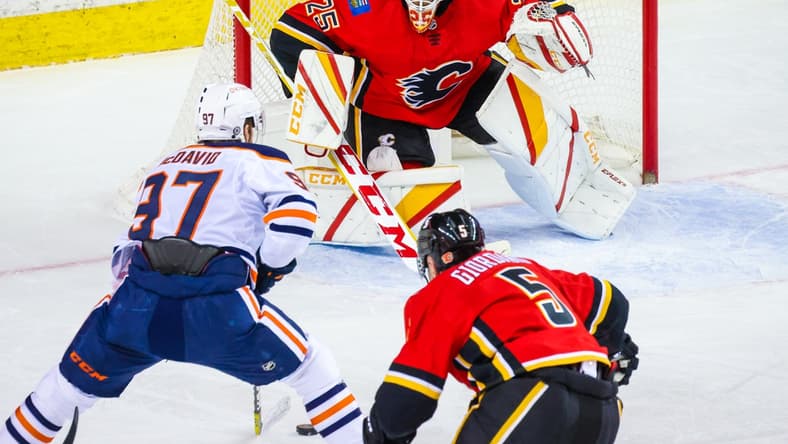 Mar 17, 2021; Calgary, Alberta, CAN; Calgary Flames goaltender Jacob Markstrom (25) guards his net against Edmonton Oilers center Connor McDavid (97) during the second period at Scotiabank Saddledome. Mandatory Credit: Sergei Belski-USA TODAY Sports