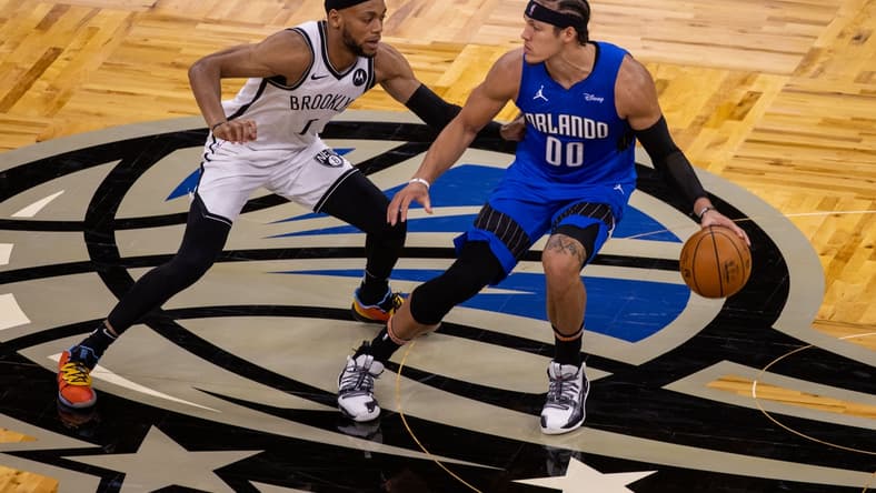 Mar 19, 2021; Orlando, Florida, USA;  Orlando Magic forward Aaron Gordon (00) drives down the court in the second quarter against Brooklyn Nets forward Bruce Brown (1) at Amway Center. Mandatory Credit: Nathan Ray Seebeck-USA TODAY Sports