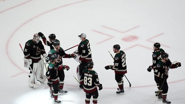 Mar 26, 2021; Glendale, Arizona, USA; Arizona Coyotes players celebrate after defeating the San Jose Sharks at Gila River Arena. Mandatory Credit: Joe Camporeale-USA TODAY Sports