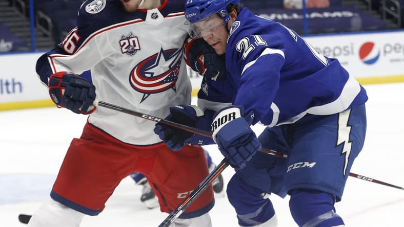 Mar 30, 2021; Tampa, Florida, USA; Columbus Blue Jackets defenseman Dean Kukan (46) and Tampa Bay Lightning center Brayden Point (21) skate with the puck during the first period at Amalie Arena. Mandatory Credit: Kim Klement-USA TODAY Sports