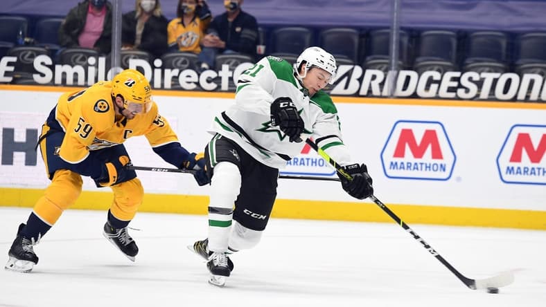 Mar 30, 2021; Nashville, Tennessee, USA; Dallas Stars left wing Jason Robertson (21) scores against Nashville Predators defenseman Roman Josi (59) during the second period at Bridgestone Arena. Mandatory Credit: Christopher Hanewinckel-USA TODAY Sports