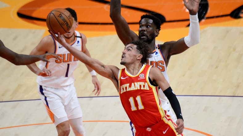 Mar 30, 2021; Phoenix, Arizona, USA; Atlanta Hawks guard Trae Young (11) shoots a layup against Phoenix Suns center Deandre Ayton (22) during the first half at Phoenix Suns Arena. Mandatory Credit: Joe Camporeale-USA TODAY Sports