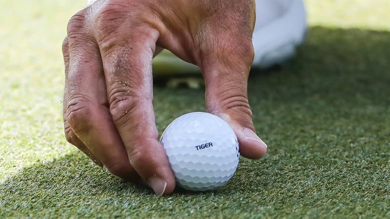 Feb 28, 2021; Bradenton, Florida, USA; Matt Kuchar places Tiger stamped ball in support go the Tiger Woods during the final round of World Golf Championships at The Concession golf tournament at The Concession Golf Club. Mandatory Credit: Mike Watters-USA TODAY Sports